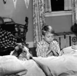 black and white photo of Lassie and Timmy kneeling to say prayers at the bedside