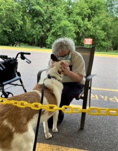 Tag kisses ronda, a white-haired woman wearing a face mask, while she presses her face into him with her hands holding either side of his head