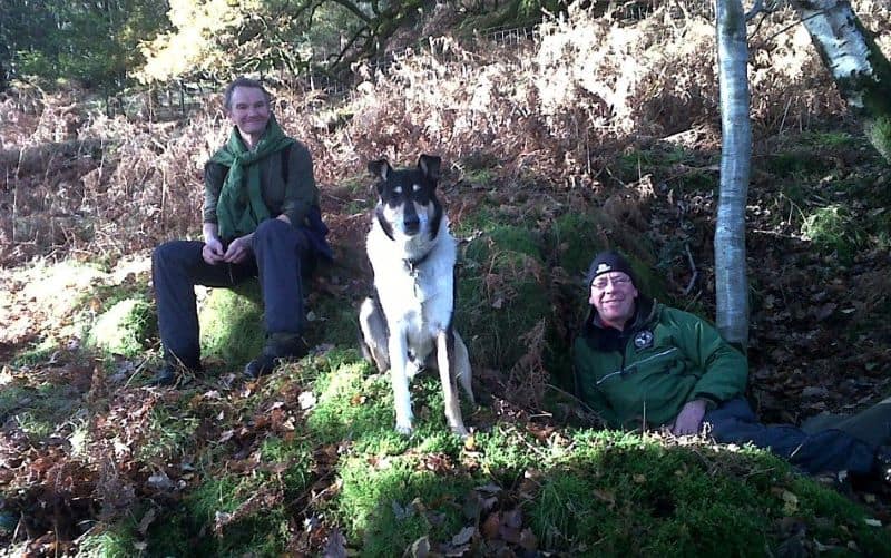 Finn sits between 2 smiling team members