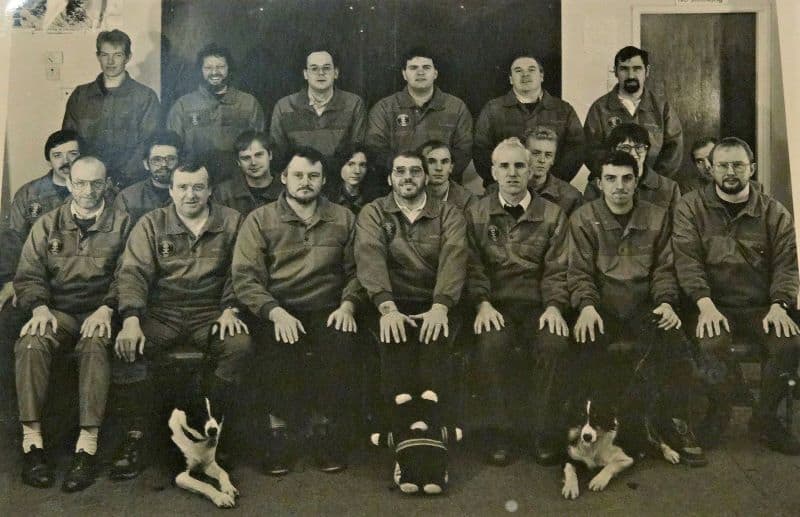 black and white group photo of rescue team, a few with dogs