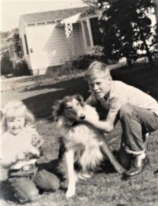 black and white photo of pam and jim sitting on the ground outside with Queenie