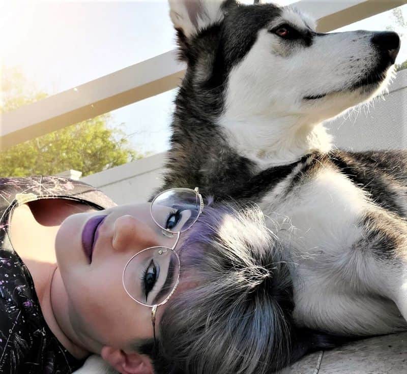 Stephanie and Lakota lie in the sun on a porch together