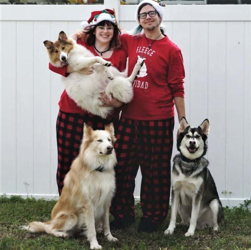 Family photo: Dylan has his arm around Stephanie, who is holding Vasya in the air in her arms, while Seneca and Lakota sit on the ground in front of them
