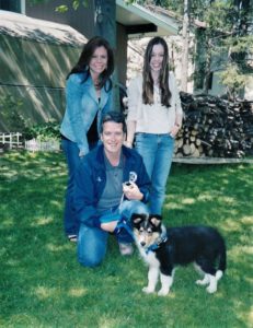 Pepsi as a puppy poses outside with Dad, Mom, and Brianna
