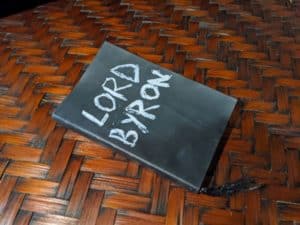 A little black notebook with "Lord Byron" handpainted on the color in white lettering
